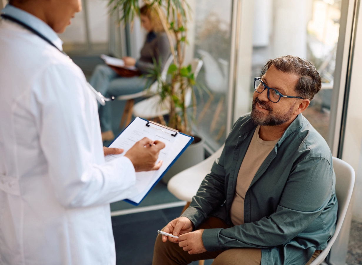 Doctor consulting with seated patient in clinic. Doctor consulting with seated patient in clinic.